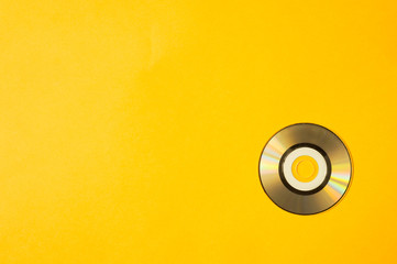 Mini compact disc on yellow background. copy space