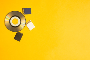 Memory card and digital disc isolated on yellow background. sd card and cd macro. copy space