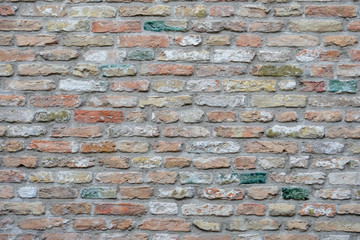 rot graue Ziegelwand, Mauer aus Backsteinen mit bunten farbigen Ziegelsteinen, rot, grün, grau, braun im Sommer in Brügge, Belgien, rote Wand Textur, als Hintergrund.