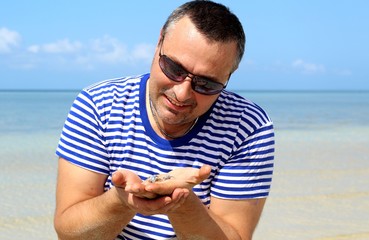 A man holds in the palms of blue Filipino crabs