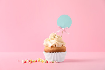Delicious birthday cupcake on color background