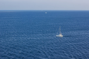 Fototapeta premium small white luxury yacht on sea surface tropic warm south natural environment summer vacation concept aerial shot from above, copy space 