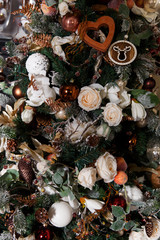 Photo of decorated Christmas tree with cones, white flowers