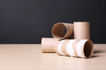 Empty toilet paper rolls on wooden table. Space for text