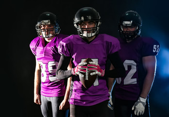 Obraz na płótnie Canvas American football players in uniform on dark background