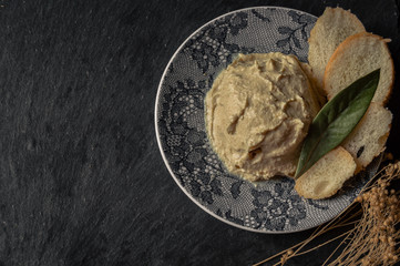 Original hummus with laurel and bread to spread. Beautiful presentation of a delicious dish made with legumes. Background with copy space.