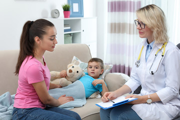 Children's doctor visiting little boy at home