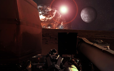Mission InSight Mars Lander near the red  planet and moon with lens flare. Elements of this image were furnished by NASA. © ALEXANDR YURTCHENKO