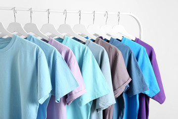 Men's clothes hanging on wardrobe rack against white background