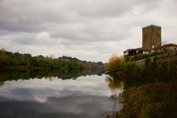 Fototapeta na wymiar Vista do Rio Minho espelhado com reflexo da outra margem, num dia de outono.