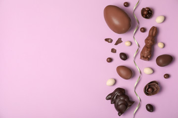 Flat lay composition with chocolate Easter eggs and space for text on color background