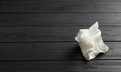 Crumpled paper napkin and space for text on wooden background