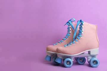 Pair of stylish quad roller skates on color background. Space for text