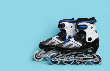 Pair of inline roller skates on color background. Space for text