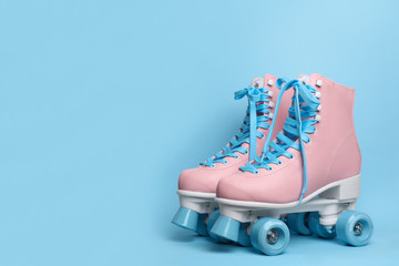 Pair of stylish quad roller skates on color background. Space for text
