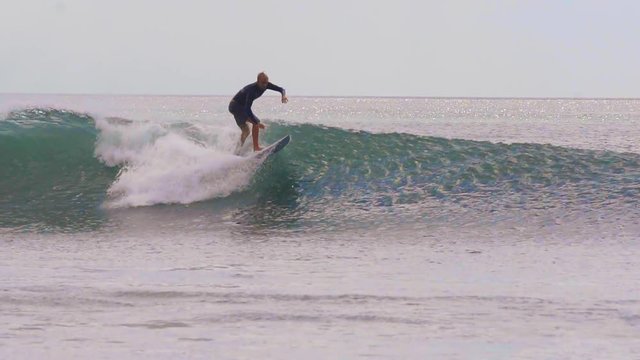 SLOW MOTION: A pro surfer is doing the tricks on a fun wave in Nicaragua