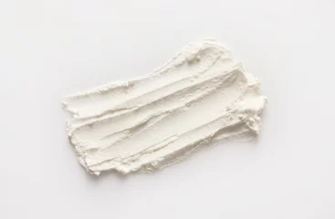 Stoff pro Meter Smear of tasty cream cheese on white background, top view © New Africa