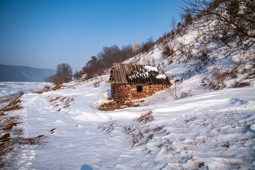 Old stone house by the river in winter