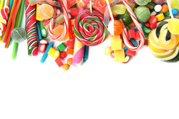Many different yummy candies on white background, top view. Space for text