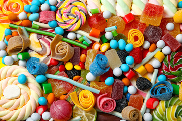 Fototapeta na wymiar Many different yummy candies as background, top view