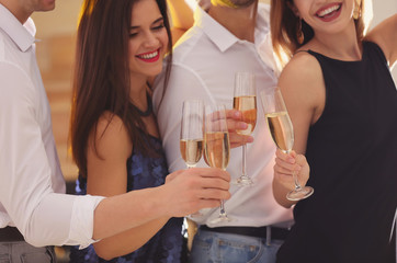 Friends clinking glasses with champagne at party, closeup