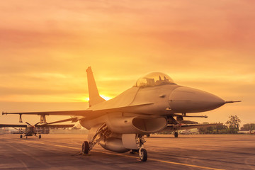 Fototapeta na wymiar Falcon fighter jet military aircraft parked on runway in the base airforce standby ready to take off for military mission on sunset
