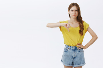 Moody disappointed and upset cute young slim woman with cute braid in yellow t-shirt and shorts...