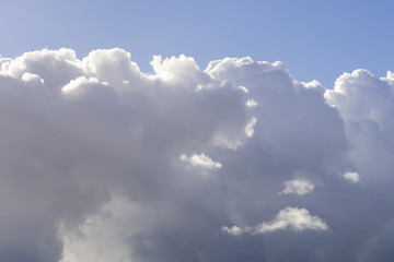 Dramatic cloudy sky, white and gray clouds moving across the sky with blue sky above, nature background