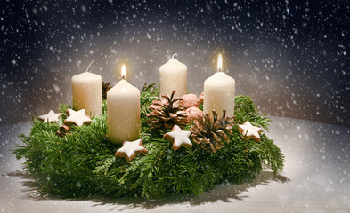 Advent wreath from evergreen branches with white candles, the second is burning for the time before...