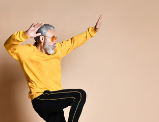 Happy senior millionaire man dancing in yellow sunglasses stylish fashionable men senior