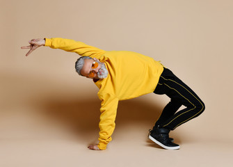 Happy senior millionaire man dancing in yellow sunglasses stylish fashionable men senior