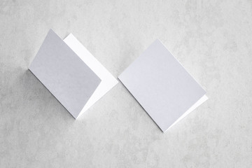 Fototapeta premium Blank portrait mock-up paper. brochure magazine isolated on gray, changeable background / white paper isolated on gray cement backdrop.