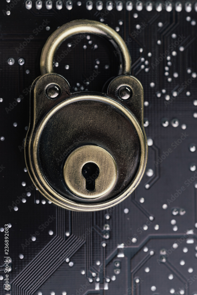 Poster lock pad on dark black computer circuit board with solder, safety and security, data encryption conc