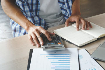 Close up hands of businessman using calculator and preparing tax payment