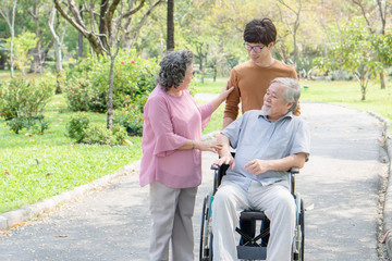 Happy asian family. Grandson take care grandma in the park.