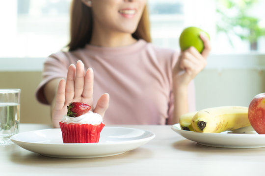 woman refusing to eat sweet bakery or cake during diet session for slim shape and good health.