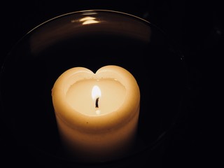Heart shaped wax candle with blame burning 
