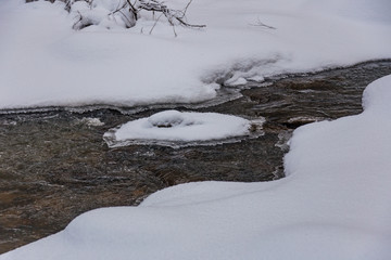 Stream in a magical winter forest on Christmas Eve, Altai, Russia