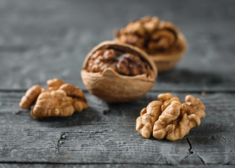 Cracked walnuts on a dark wooden table.