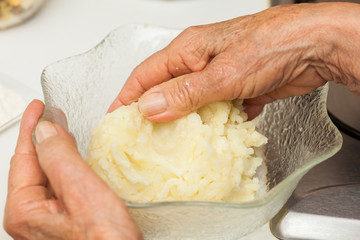 Preparation steps of traditional Colombian dish called stuffed potatoes: Kneading the mashed potatoes by hand to form a dough for the stuffed potatoes