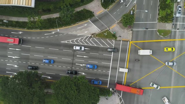 Top view of a city intersection with a bus, cars and people crossing the street. Shot. Traffic at daytime, rossroad in the center of big city, aerial top view.