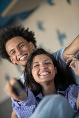 Obraz premium Young black couple relaxing on couch and smiling at camera