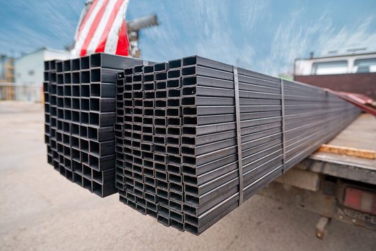 Bent metal profile channel on the truck. Ready for delivery. Steel materials, construction supplies. Coated profiles in the rack. Metal profile pipe of rectangular cross section in packs at warehouse