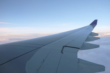 Fototapeta na wymiar Wing of airplane above the cloud in the blue sky