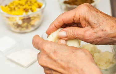 Preparation steps of traditional Colombian dish called stuffed potatoes: Kneading the mashed potatoes by hand to form a dough for the stuffed potatoes