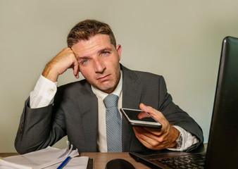 young desperate and depressed business man suffering problem and depression at office desk working...