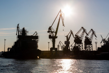 Fototapeta na wymiar Silhouette shipyard have crane machine, Shipyard industry.