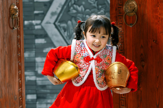 Lovely little girl holding the gold ingot