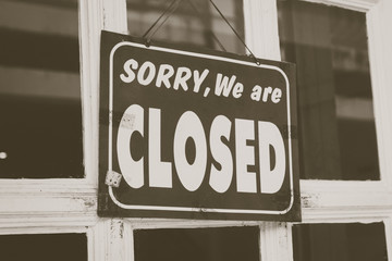 Sorry we are closed sign hang on door of business shop.