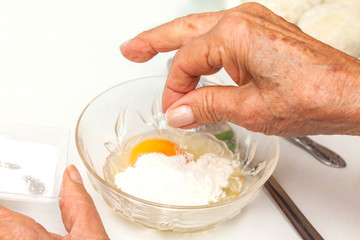 Preparation steps of traditional Colombian dish called stuffed potatoes: Preparing the egg and flour mixture to dunk potatoes